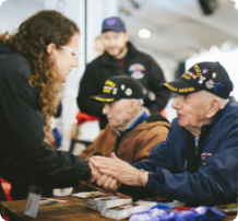 A photo of students creating intergenerational relationships with two war veterans