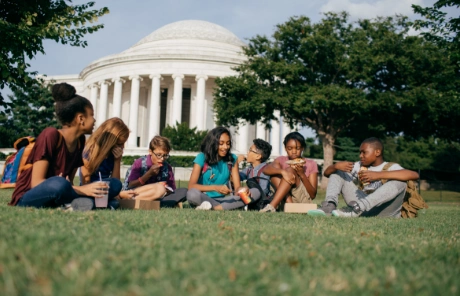 A student interacts with a robot on a class trip to Washington, D.C.Students sit outside the Jefferson Memorial on a STEM trip to Washington, D.C. 