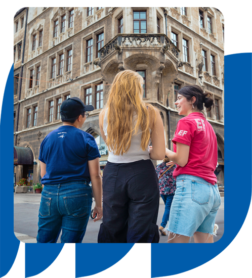 Three students walking together in front of a modern building, showcasing a vibrant urban environment.