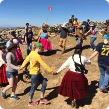 A circle of people dance in celebration of cross-cultural understanding on a Language and Culture tour 