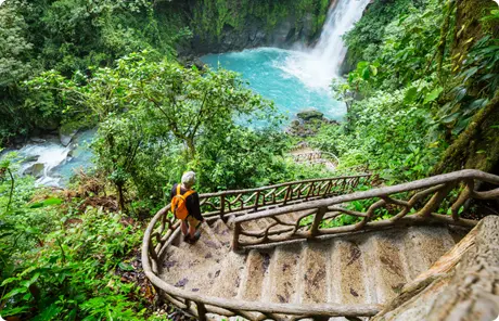 Image of a woman exploring Latin America, perhaps on a STEM travel program, as she walks down a winding, outdoor staircase toward